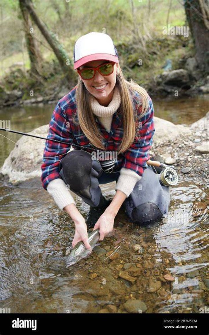 woman catching rainbow trout fly in river Stock Photo Alamy